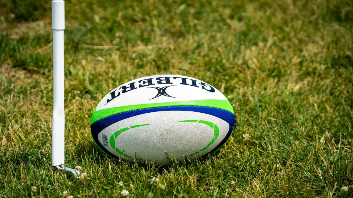 a rugby ball sitting on top of a lush green field