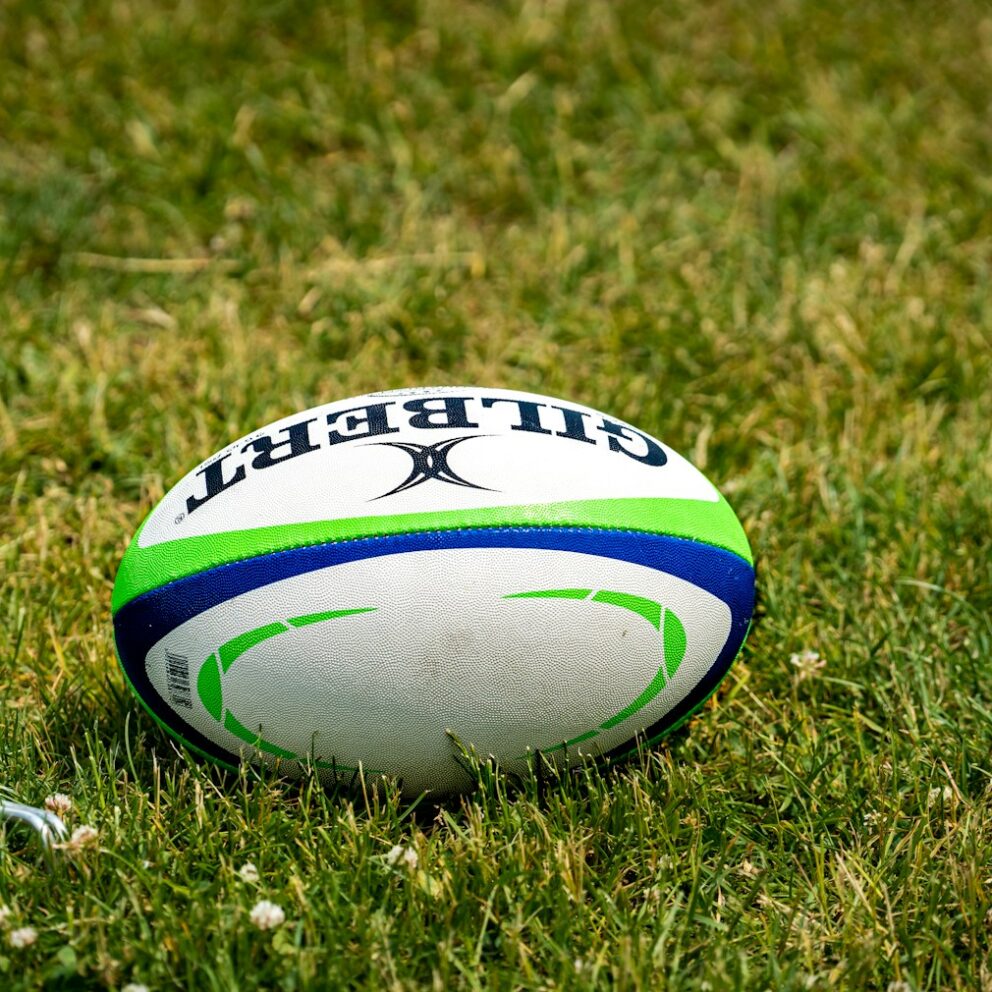 a rugby ball sitting on top of a lush green field